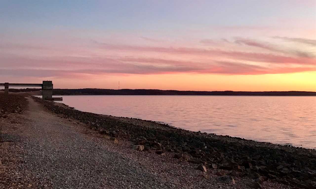 Sunset over a lake with golden-crimson sky.