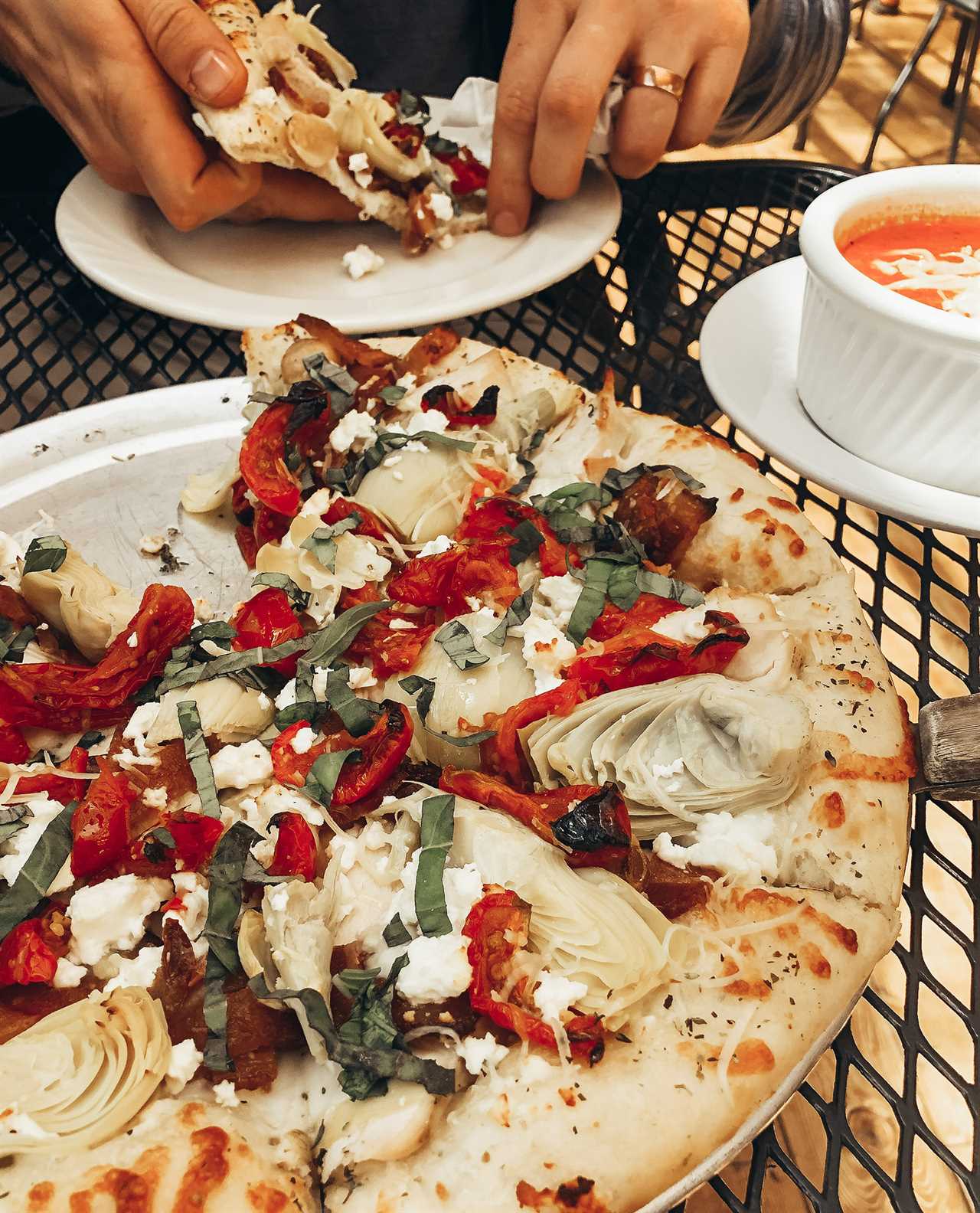 A pizza laden with artichoke, sun-dried tomatoes and ricotta cheese.