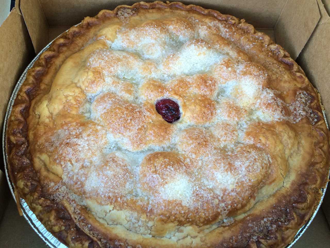 A cherry pie covered with sugar and coated with crust.
