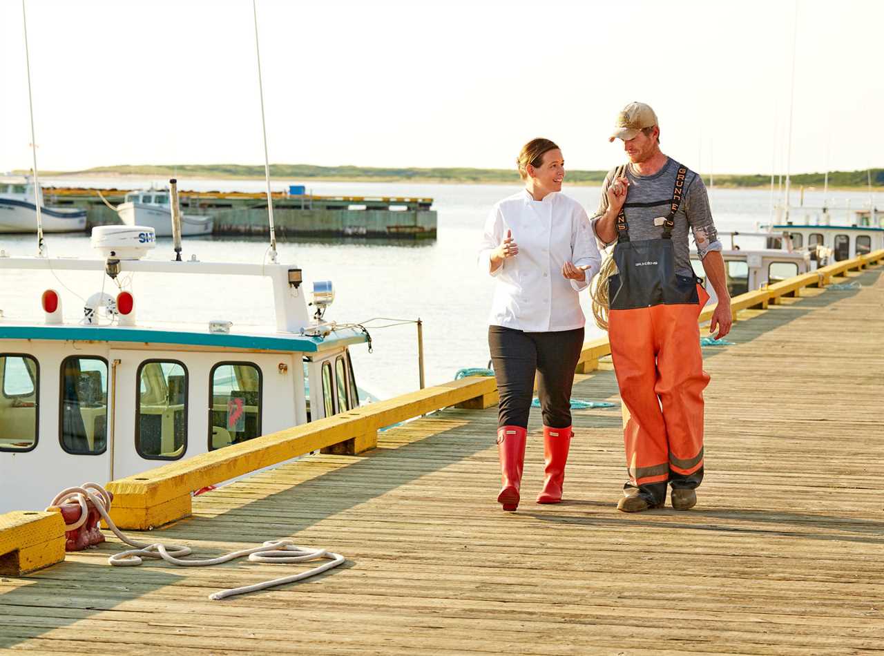 A chef and fisherman in animated conversation on boat dock.