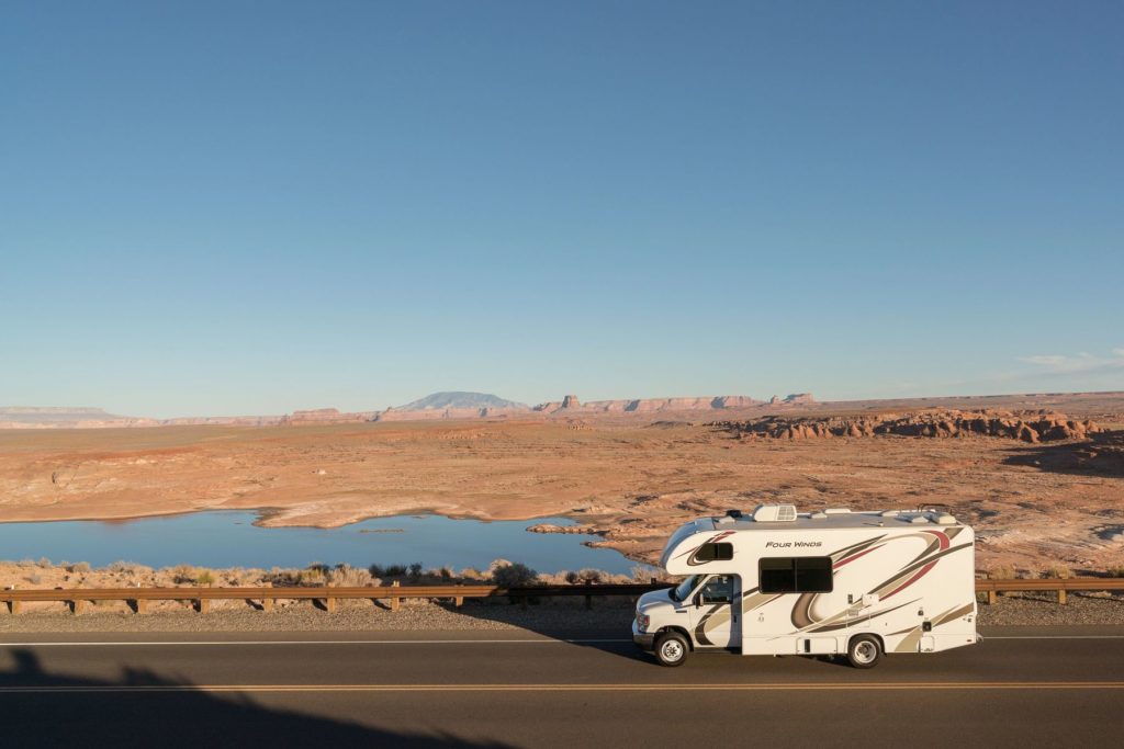 RV Driving on Back Road Along Water