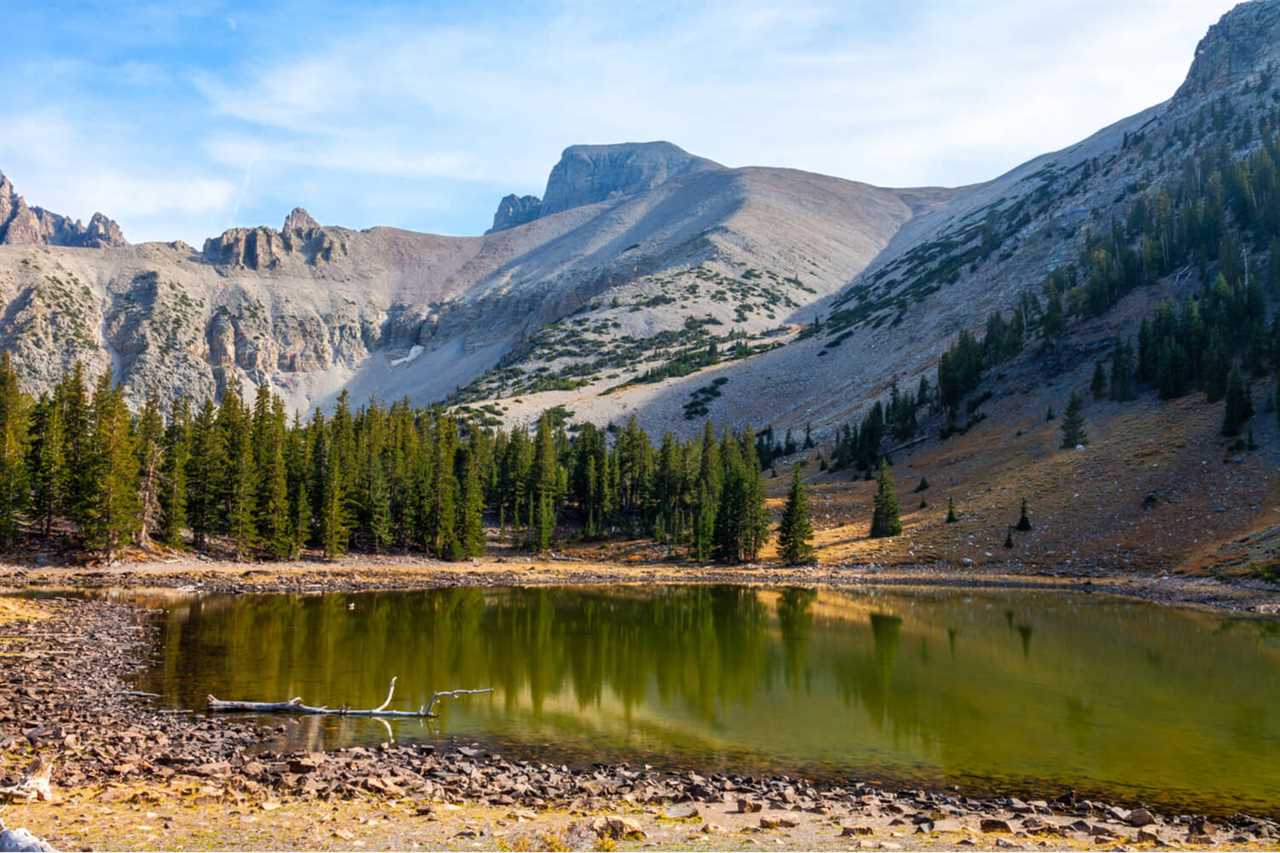 A small pond surrounded by high, gray mountains