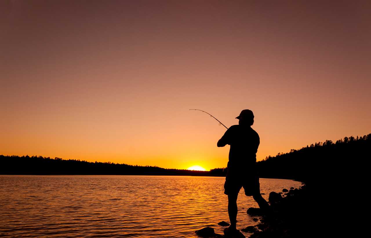 Man casts a line as the sun rises on the horizon.