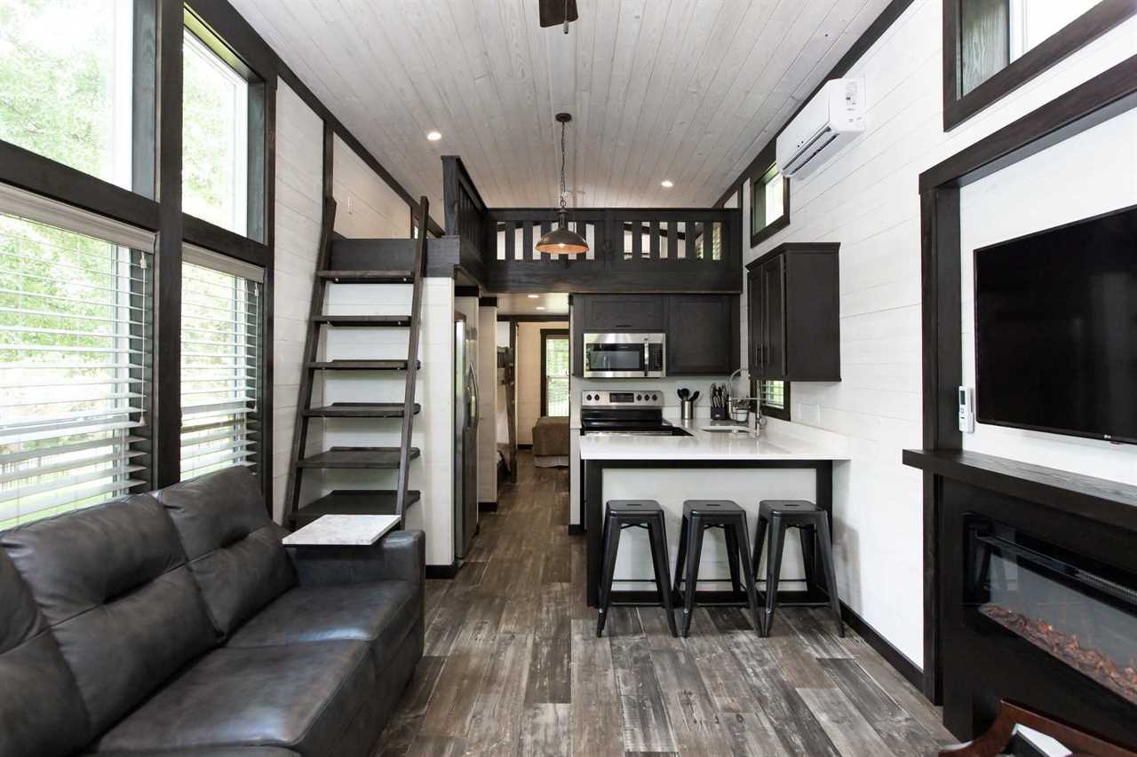 Kitchen and loft with coffee-colored floors and white walls and ceiling.