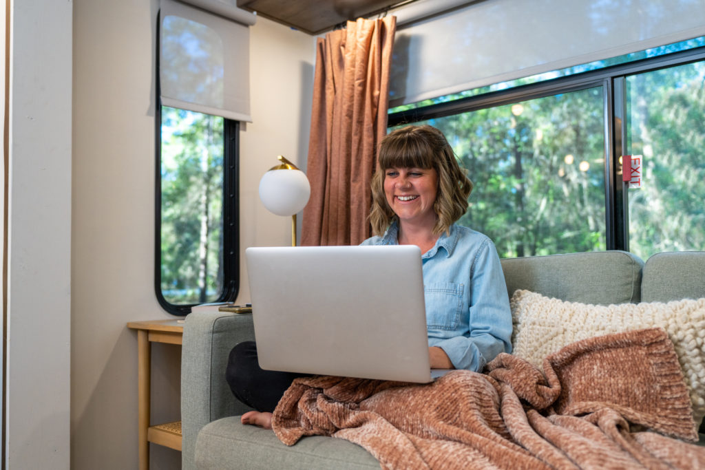 Woman Working Remotely on Laptop from RV Sofa