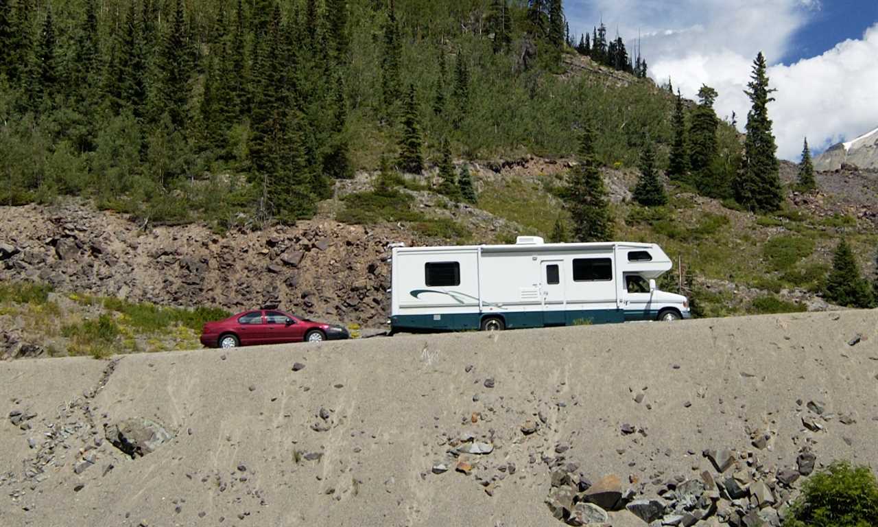 A Class C motorhome towing a car, a toad