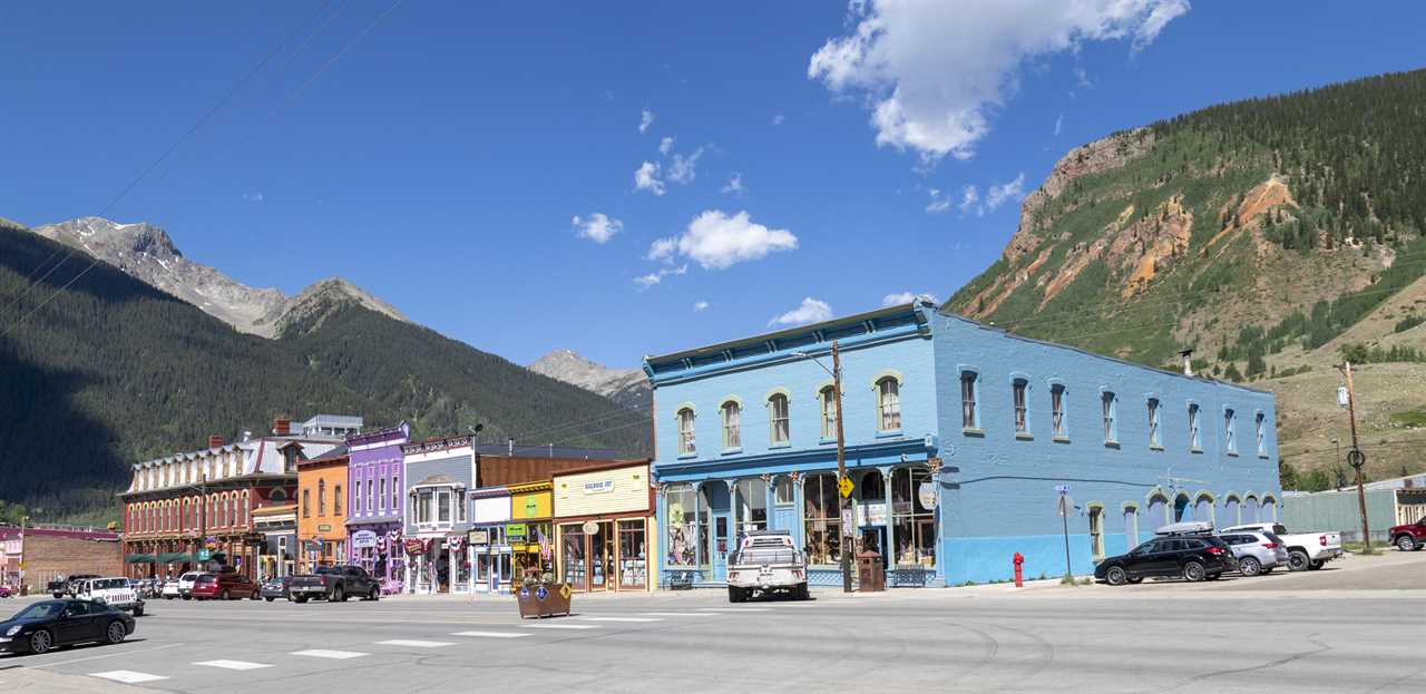Colorful building in an Old West town with mountains towering in the background.