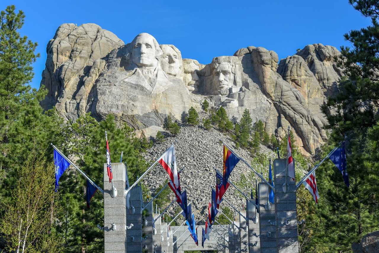 A corridor of state flags leading to Mount Rushmore.