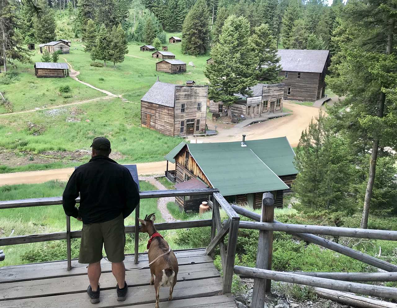 Man standing on a balcony on a high slope overlooking a ghost town.