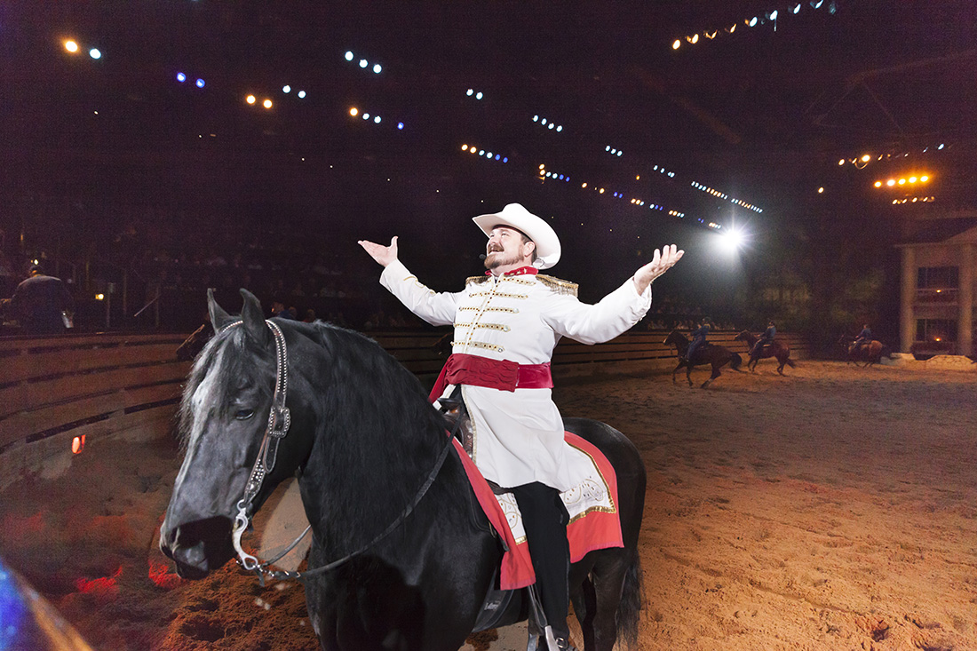 Performer on horseback accepting applause from an audience. 