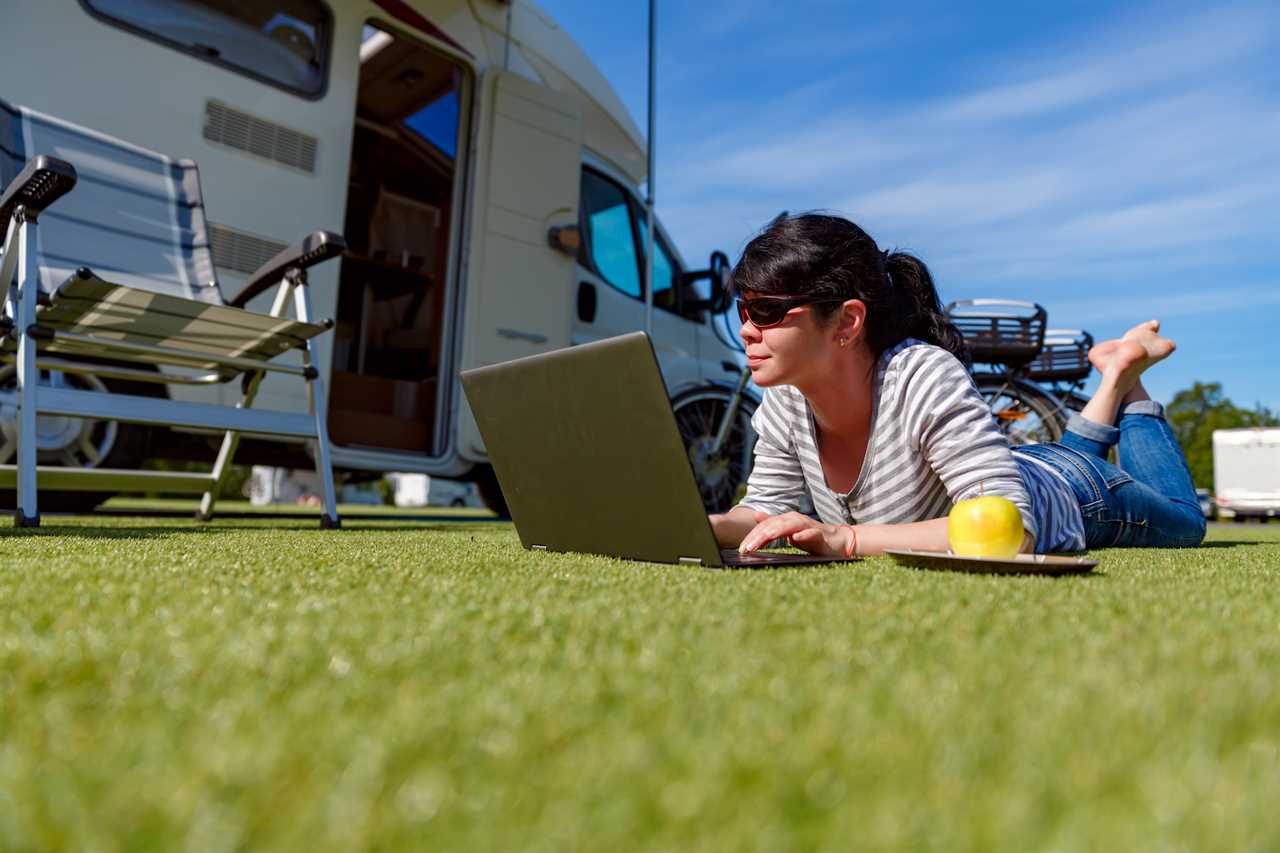 woman on laptop in front of RV.