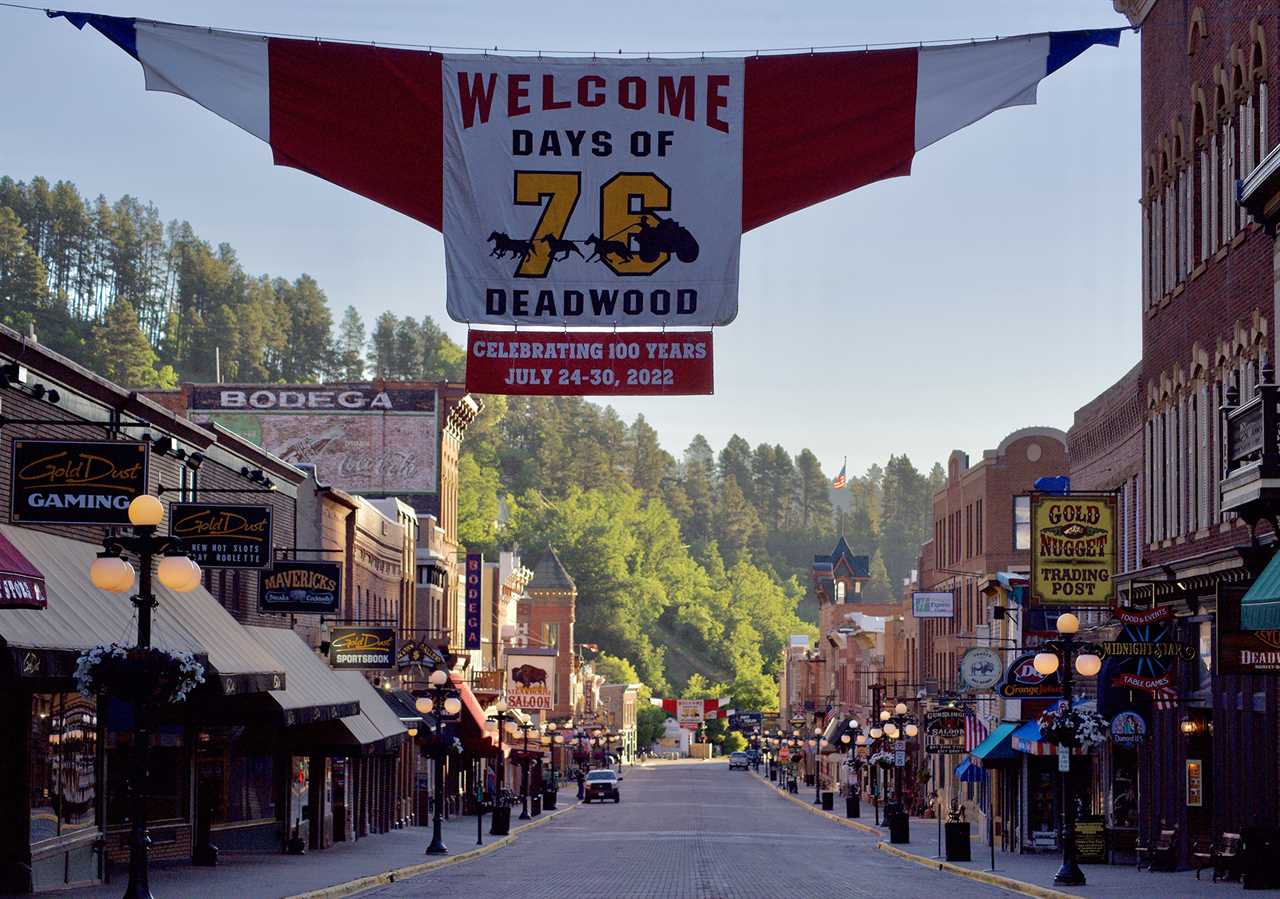 Festive banner hangs over the street of town with Old West style building facades.