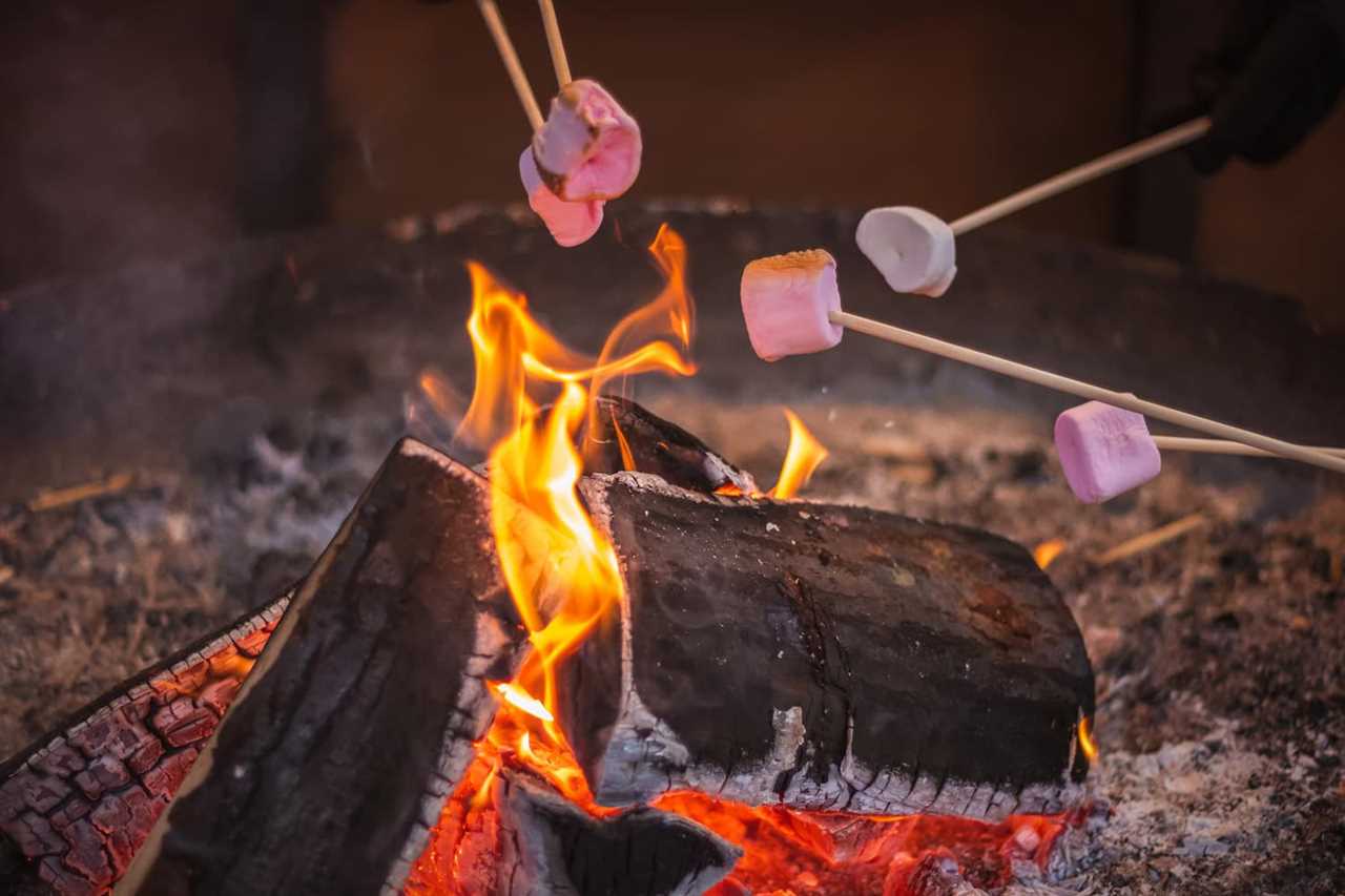 Selective focus, toasting a marshmallow over an open flame at Christmas market winter wonderland in London
