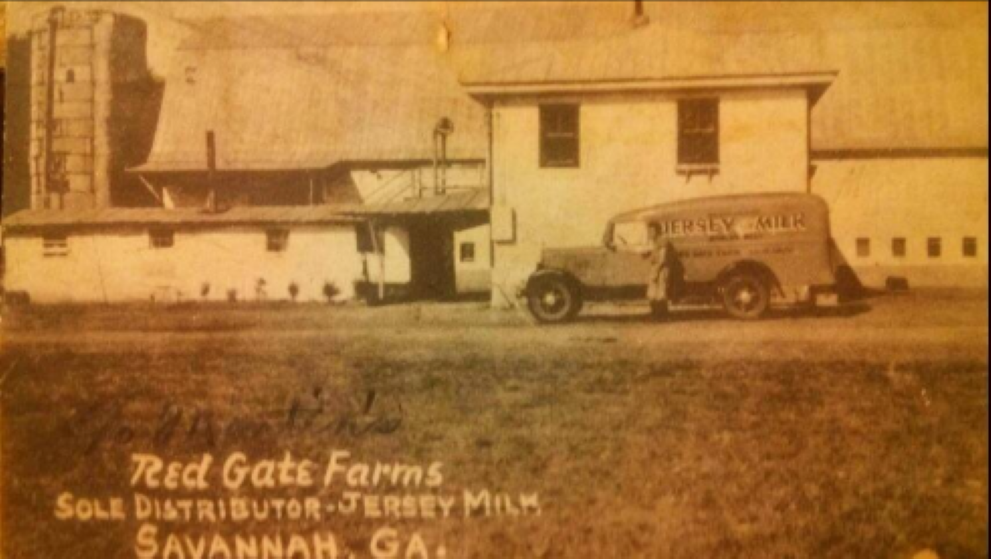 Photo in sepia tone with old truck in front of farming-grain complex.