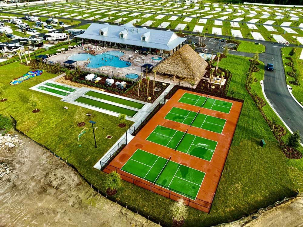 Aerial shot of RV resort with pickleball courts and lare pool