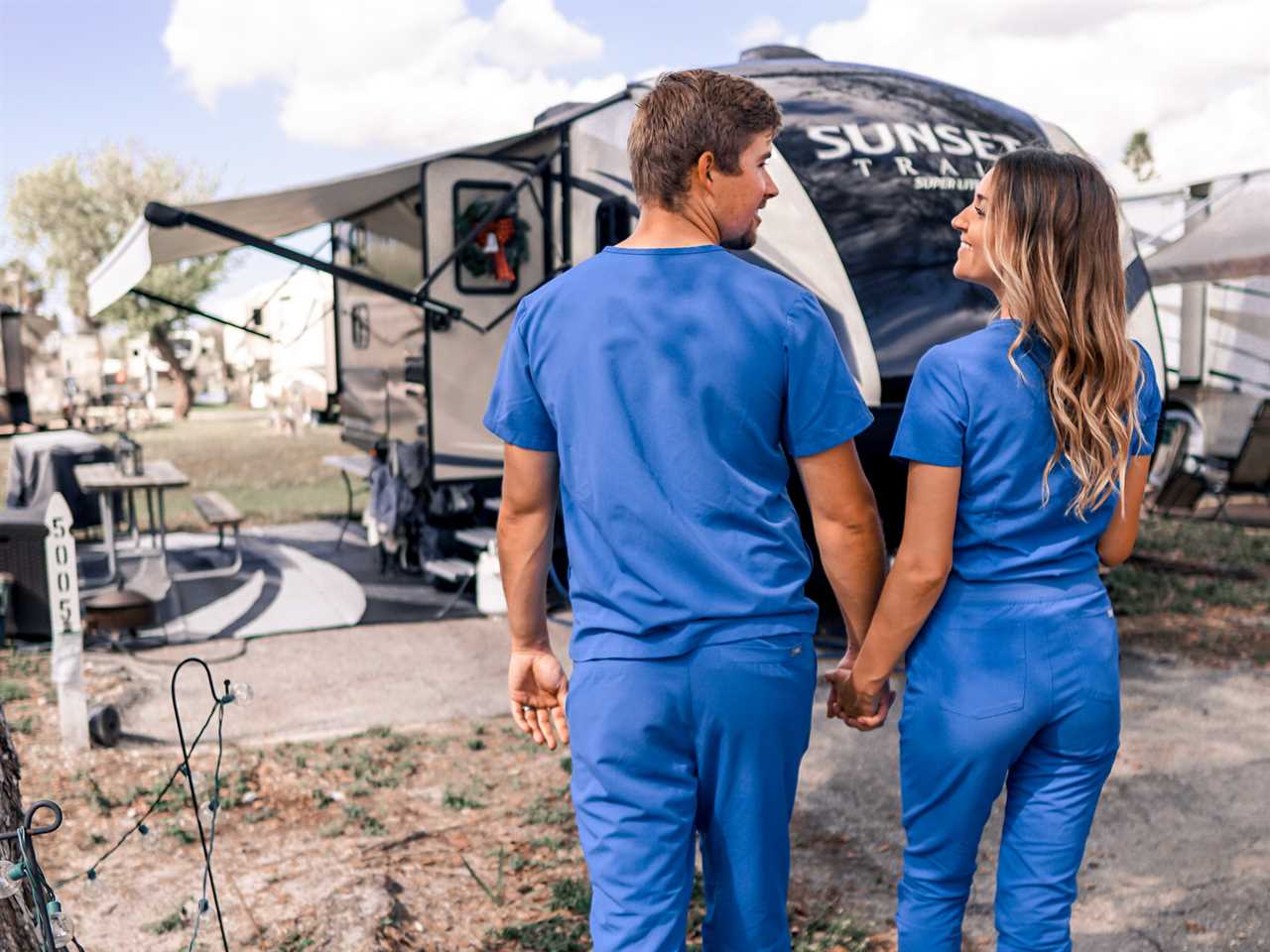 nurse couple in front of rv.