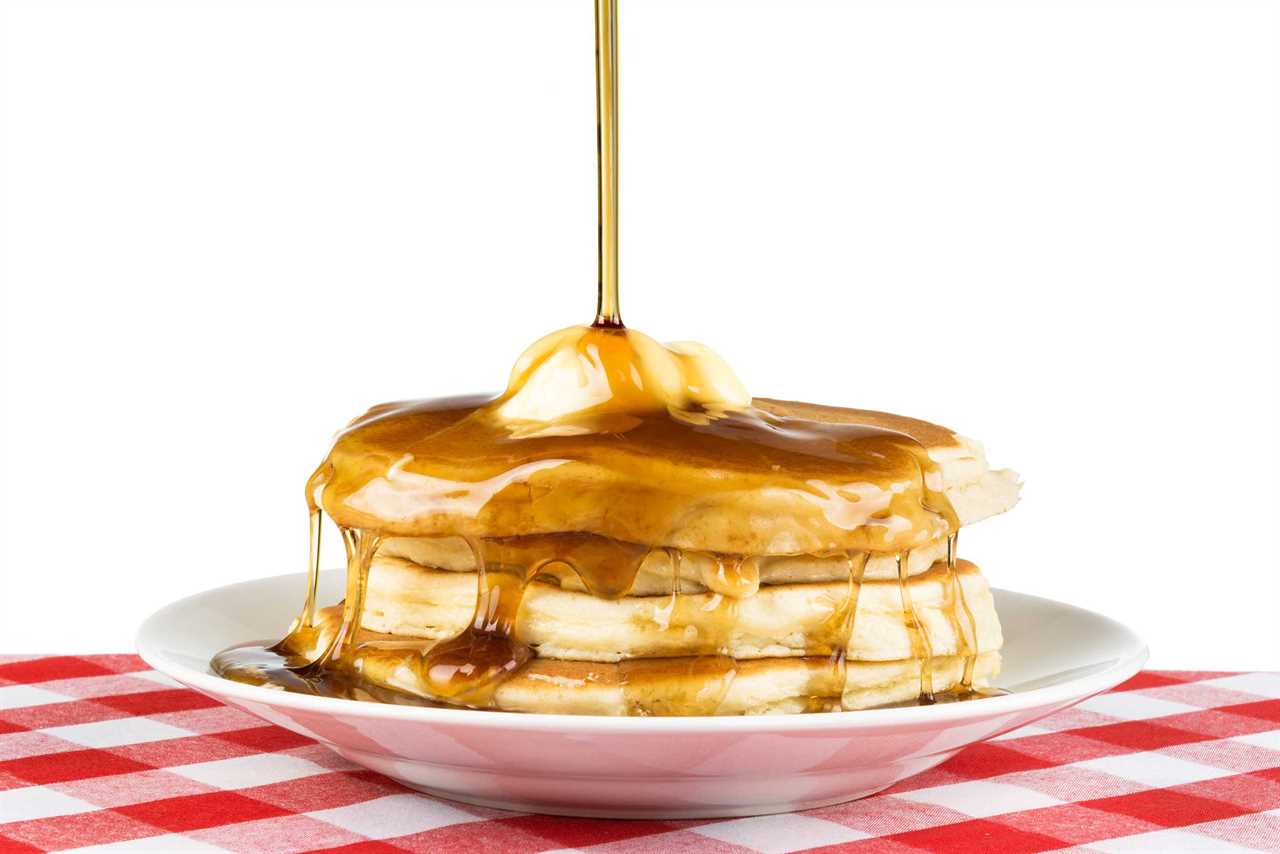 Maple syrup poured on a stack of pancakes