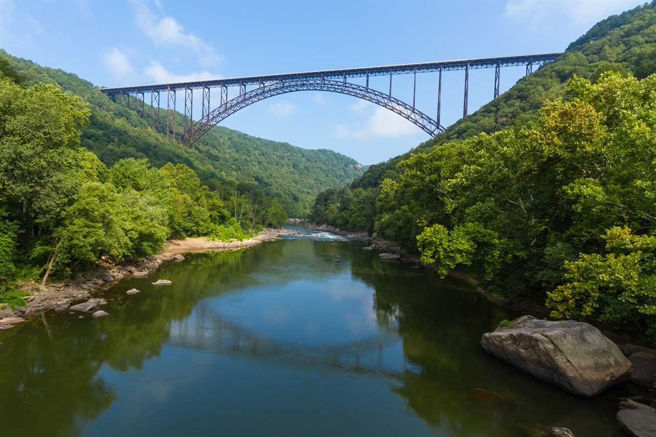 Elegant steel bridge arches over a deep river valley.