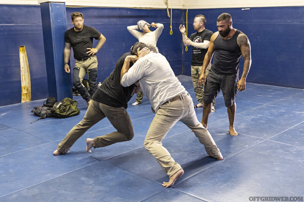 Students practice defensive grappling with a disabled handgun.