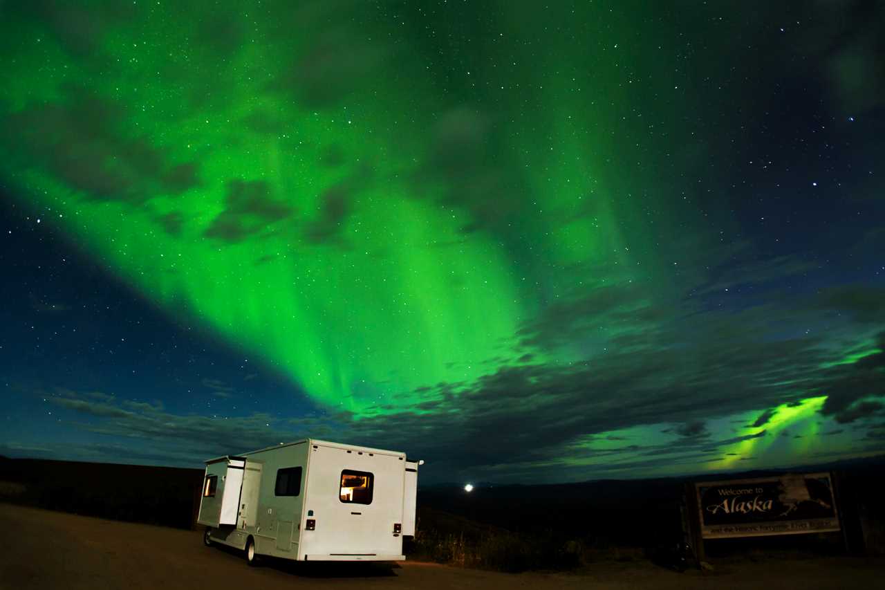 RV parked under northern lights.