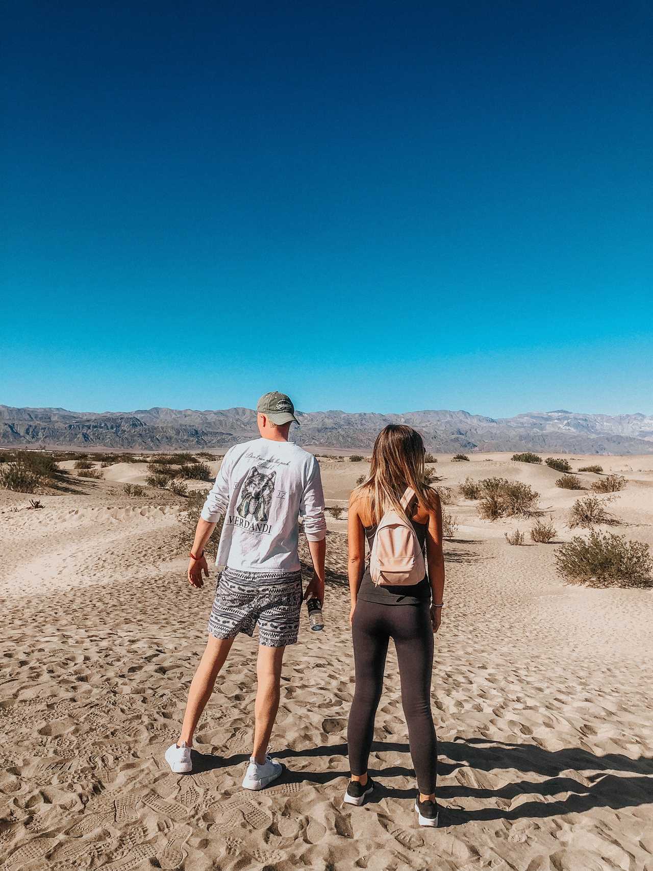 Hikers on a sandy landscape evaluate the way ahead.