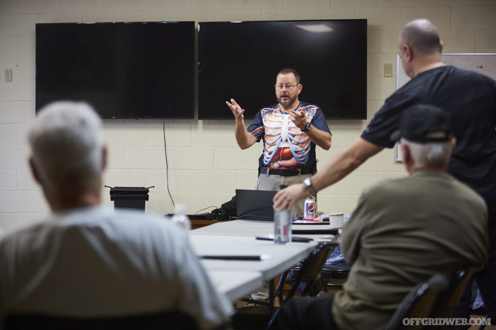 Photo of John Hearne giving a lecture inside of a classroom.