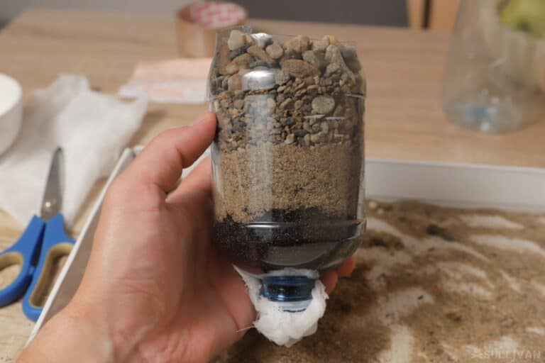 activated charcoal and gravel inside plastic water bottle
