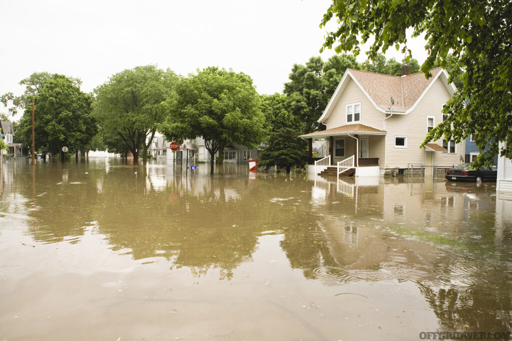 Photo of brackish flood waters enveloping a suburban housing development.