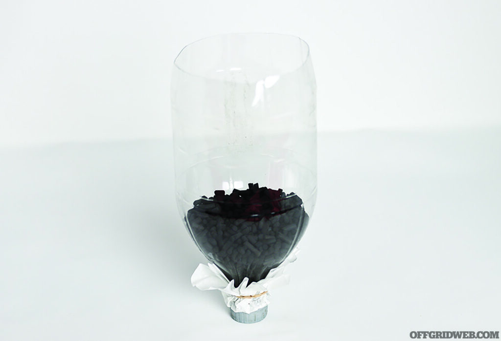Photo of an upside down, clear plastic soda bottle filled partially with activated charcoal.
