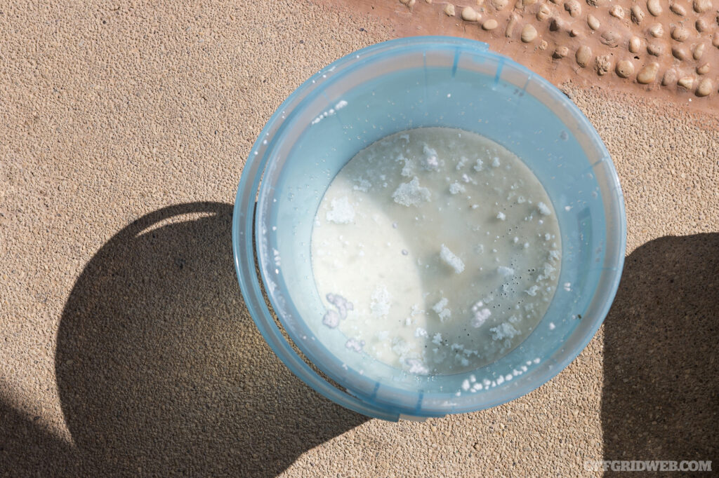 A photo of the top of a small container of partially dissolved calcium hypochlorite.