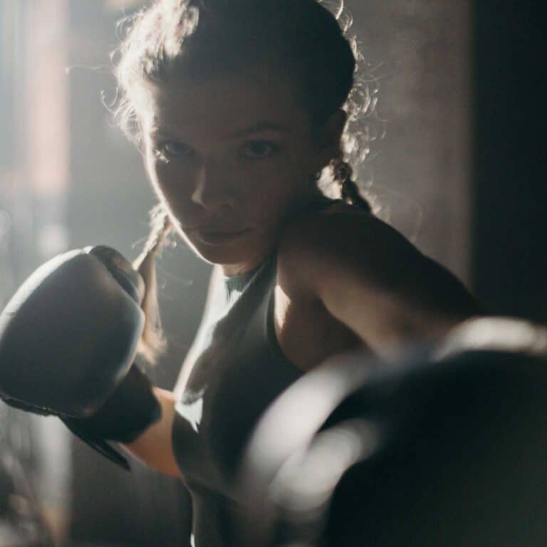 woman with black boxing gloves throwing punches