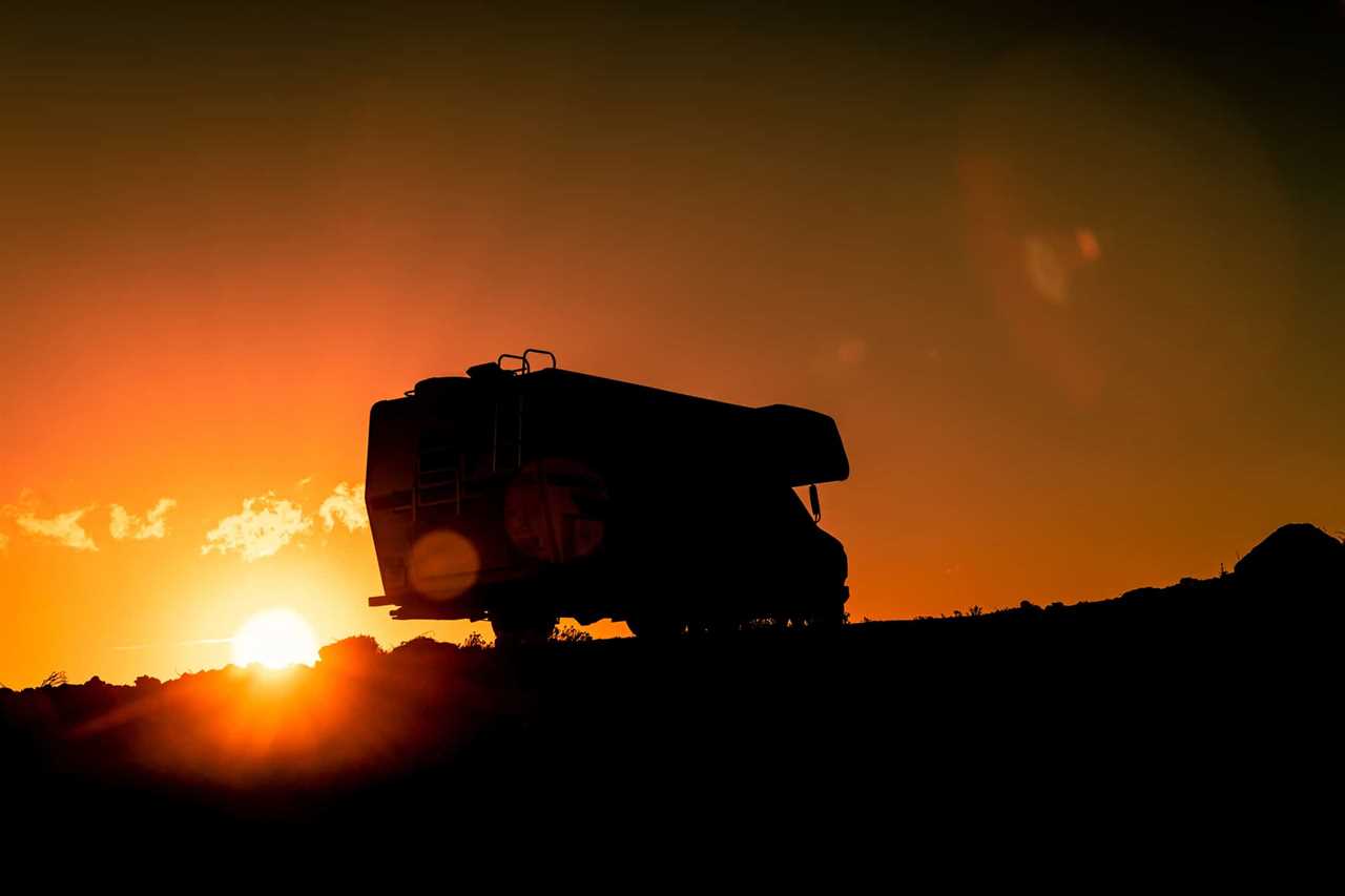 Silhouette of Class B motorhome against a setting sun.