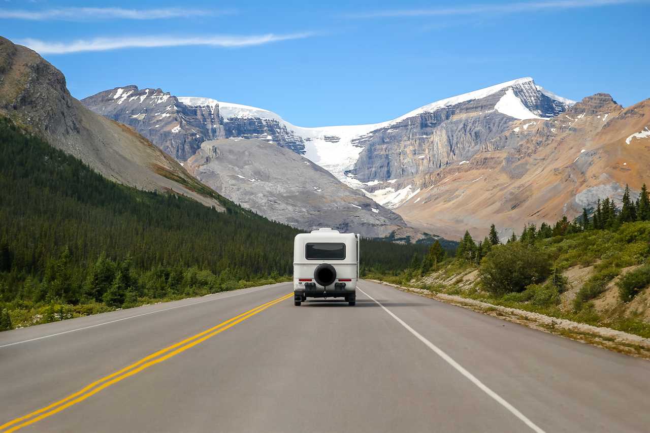 RV on highway driving toward mountains.