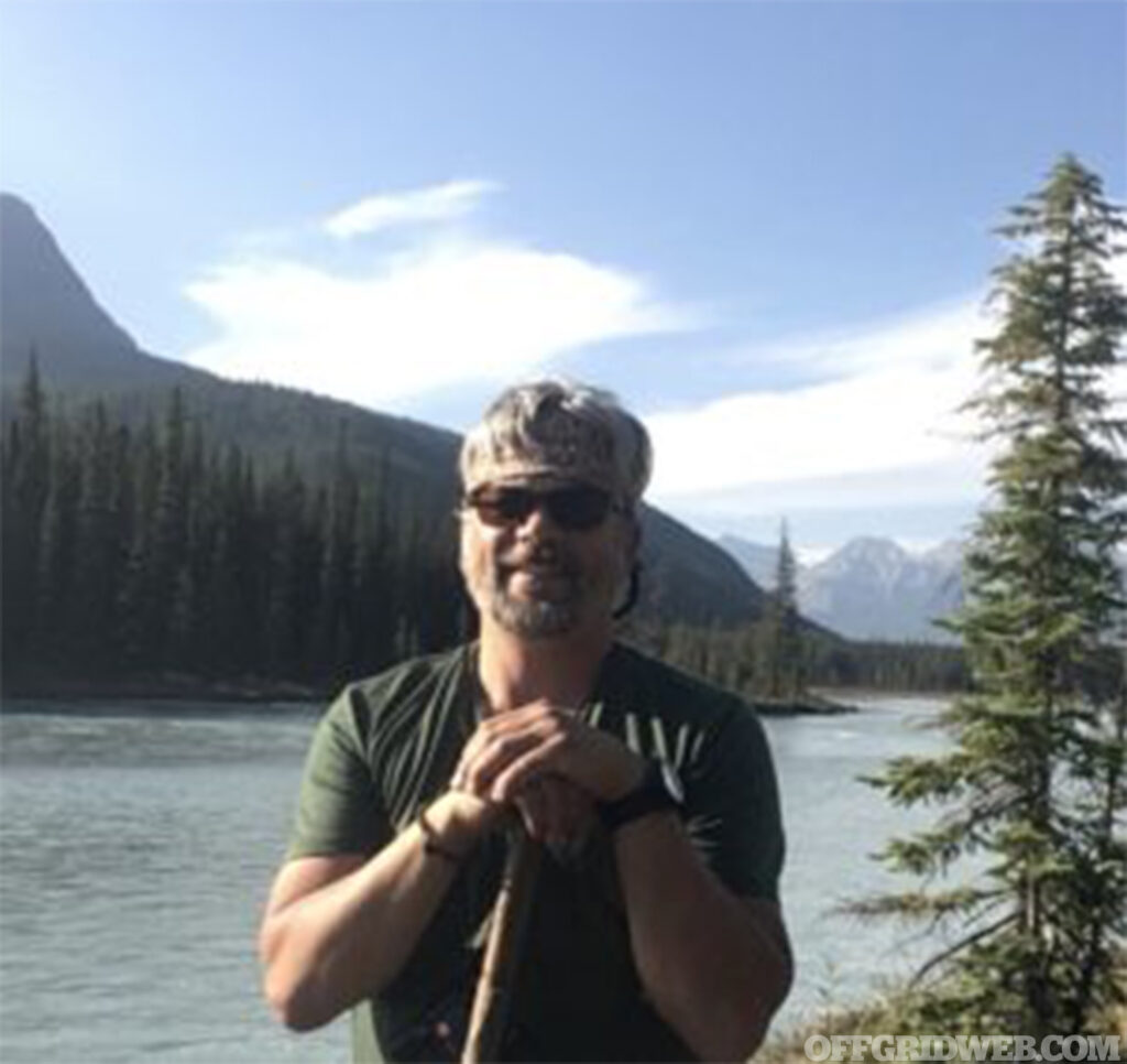 Outdoor photo of Alex Rayner with an alpine scene in the background.