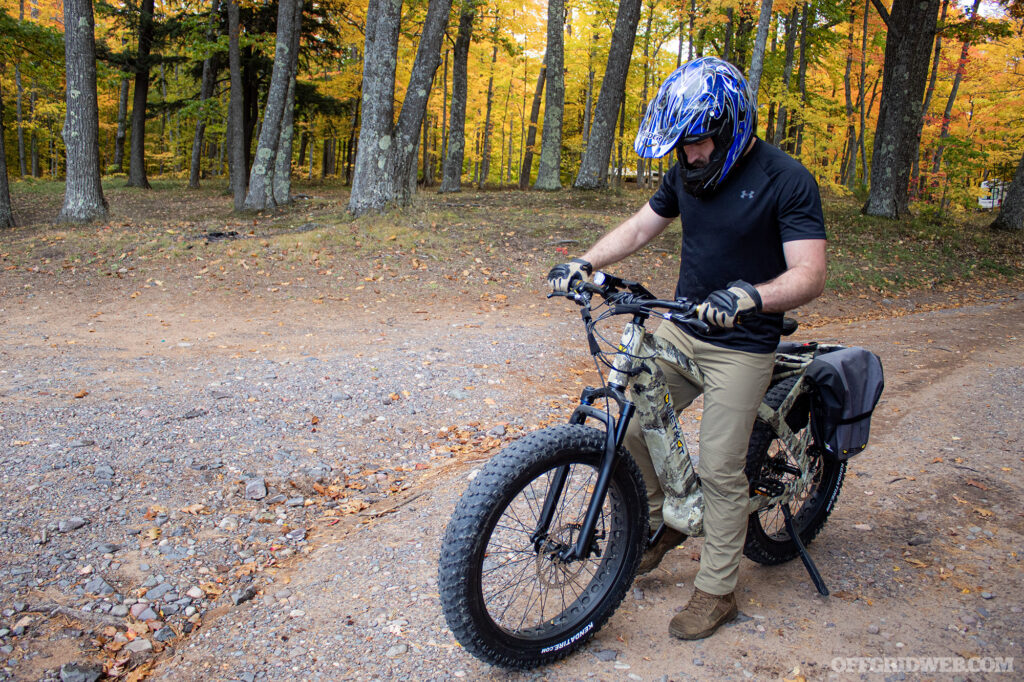 Photo of an adult male wearing a motorcross helmet getting ready to ride an eBike.