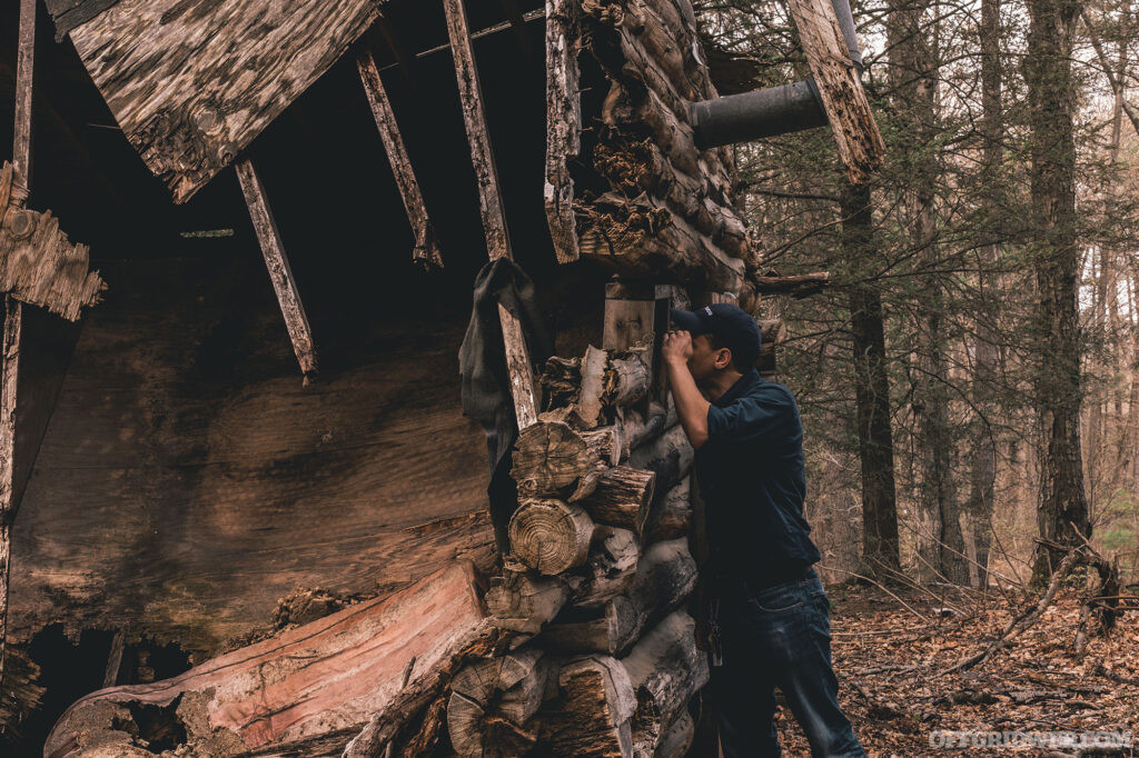 Photo of an adult male searching through abandoned ruins.