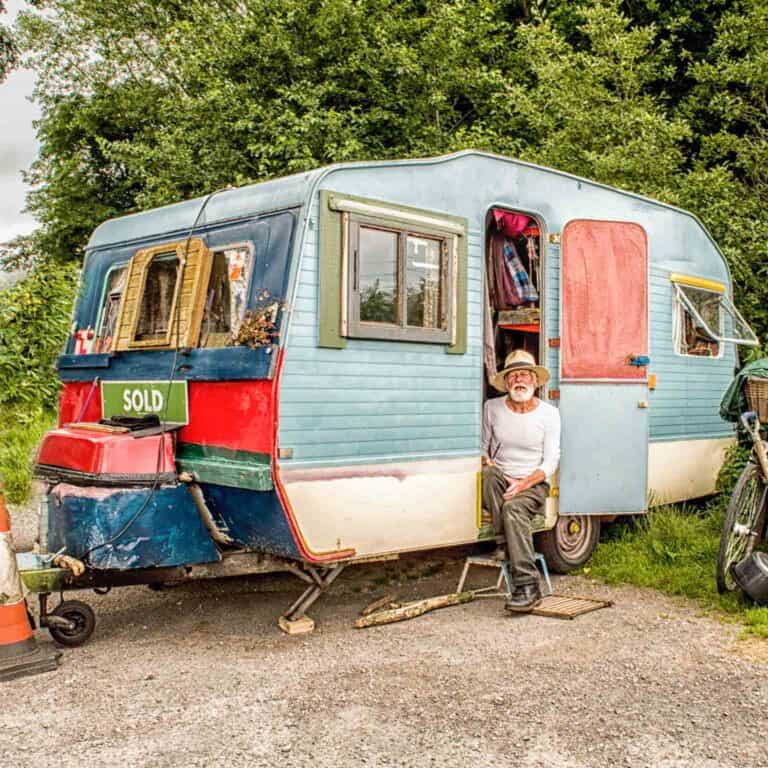 old man next to his camping trailer