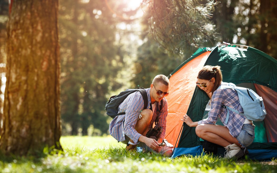 Campers setting up the tent at the forest.