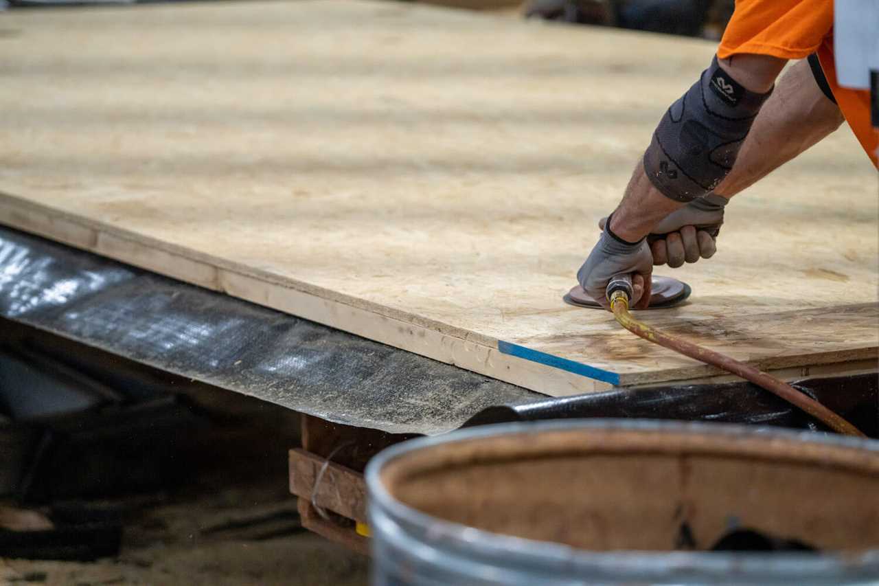 Worker sanding floor of travel trailer