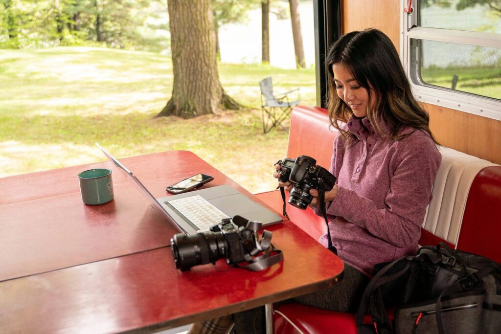 Lady looking at camera with computer on table in RV