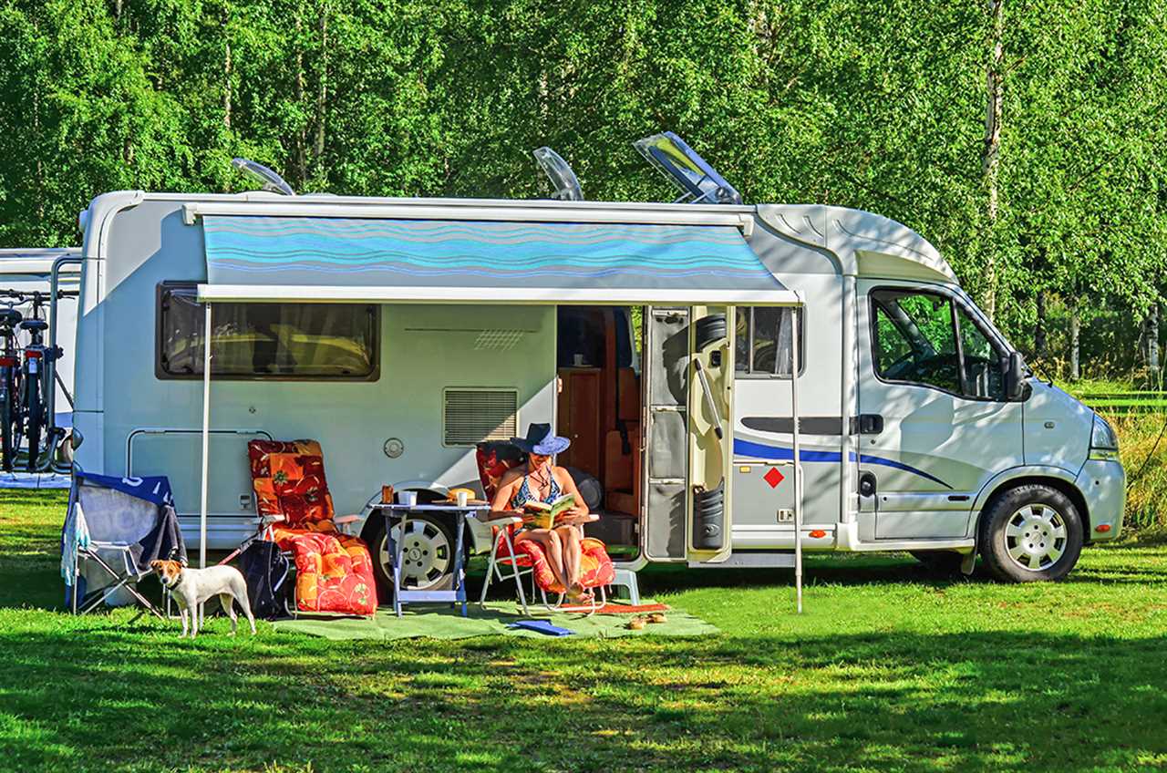 Woman lounging in RV with dog in patio area.