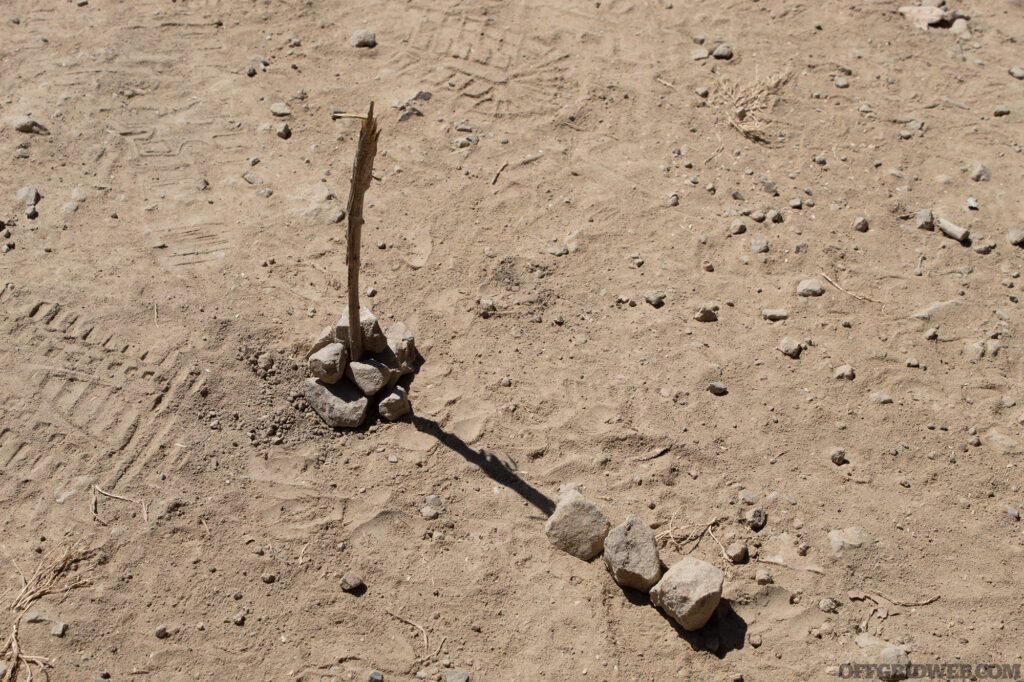 Photo of an improvised sundial with a row of rocks marking the initial point of the shadow cast by the sun.