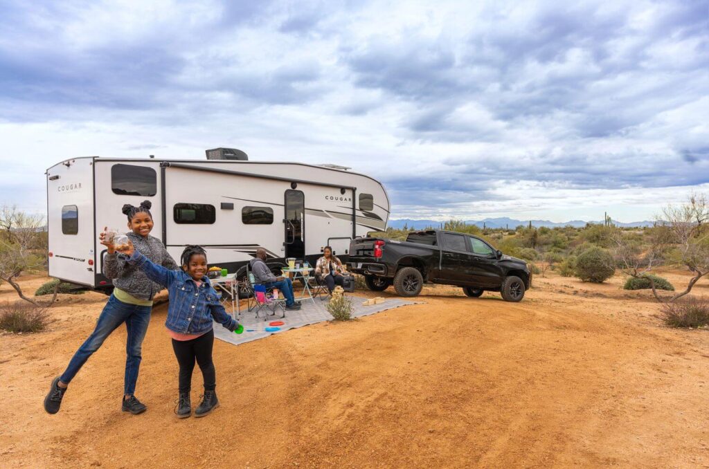 Family camping outside 5th wheel RV