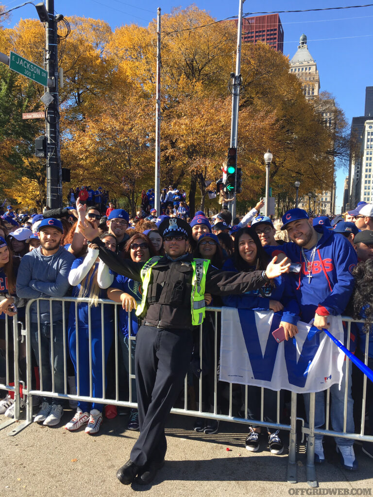 Raul Martinez posing with cheerful citizens at a parade barrier in Chicago.