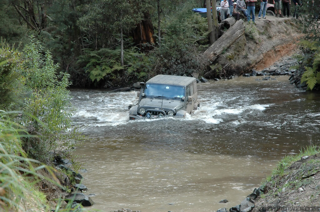 Photo of a modified Jeep Wrangler crossing a river during a flash flood.