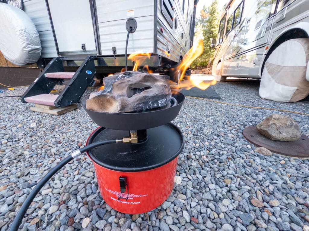 Camco portable firepit lit sitting on top of lid