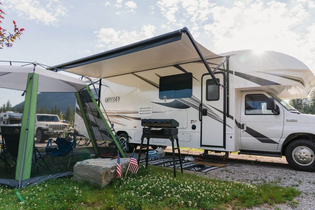 Class C RV with Awning out and campsite set up