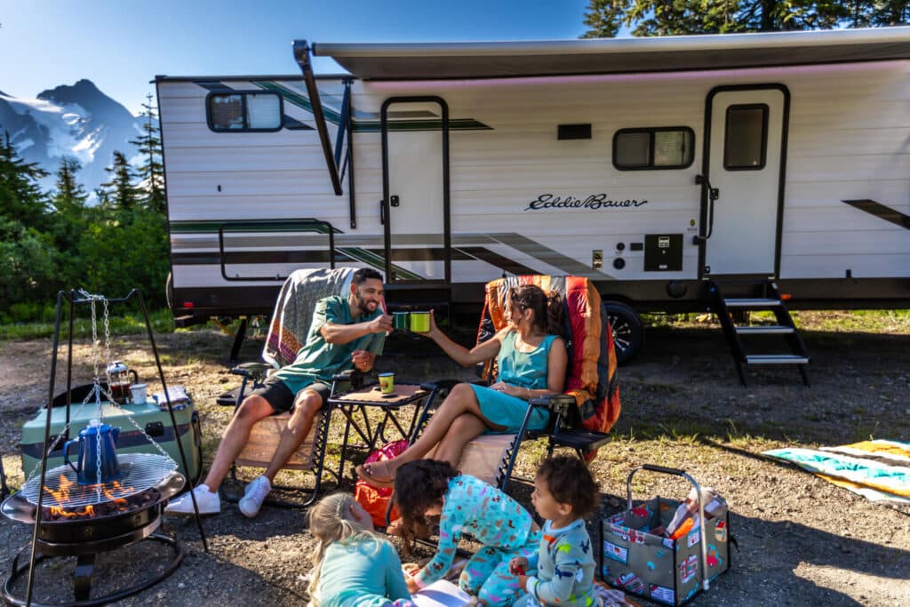 Parents and kids relaxing at campsite outside Eddie Bauer RV