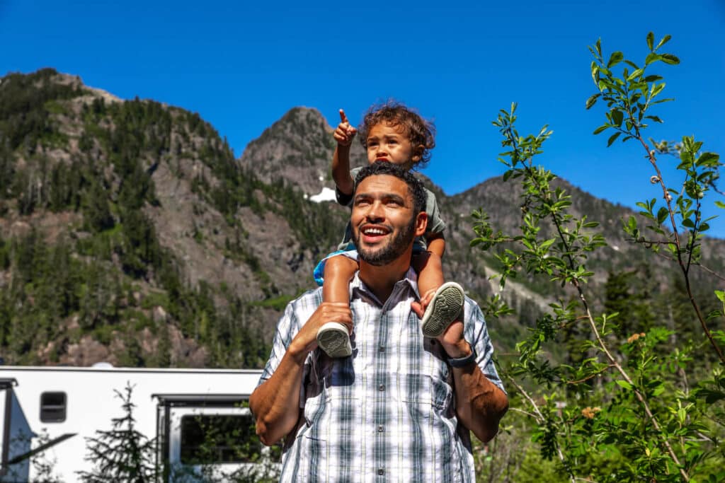 Dad with son on his shoulders looking at Eddie Bauer RVs