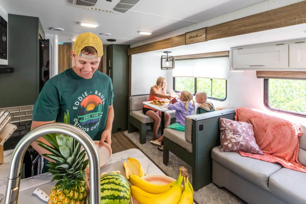 Family relaxing inside Eddie Bauer travel trailer